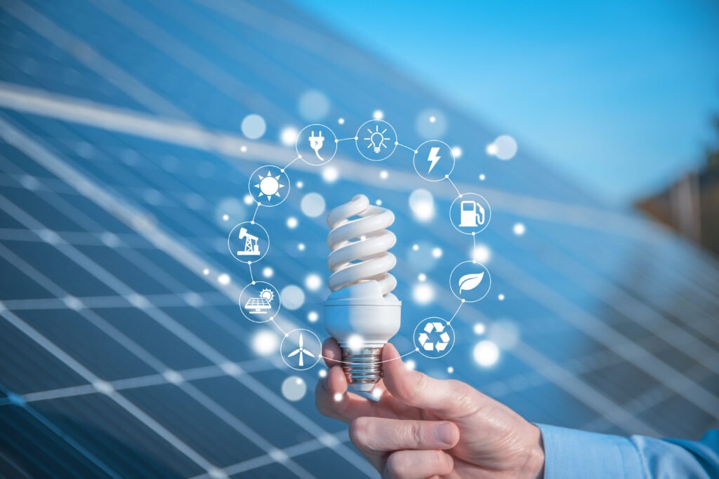 Bombilla de bajo consumo con símbolos de energías renovables sobre paneles solares.